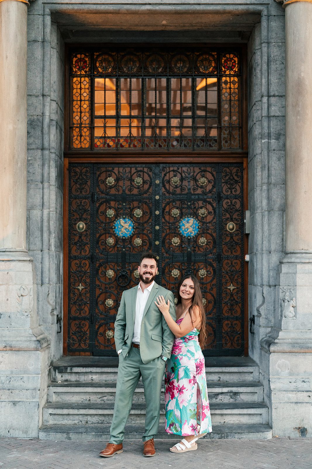 Two people standing in front of an ornate wooden door